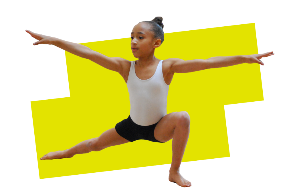 A young dancer in a white leotard and black shorts holds a strong pose in a deep lunge, her arms out to the side and her face in concentration.