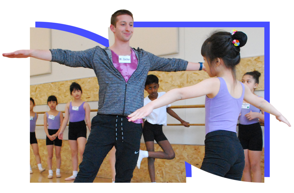 A student in a dance studio in the Introduction to Ballet class copies the teacher's movement, reaching one foot to a tendu side, and both arms outwards, preparing to dance across the floor.
